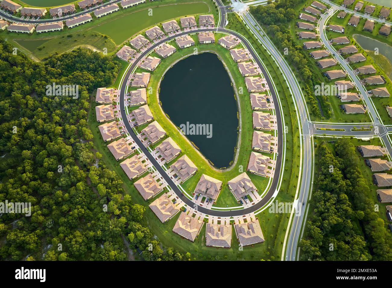 Aerial view of tightly located family houses with retention ponds to
