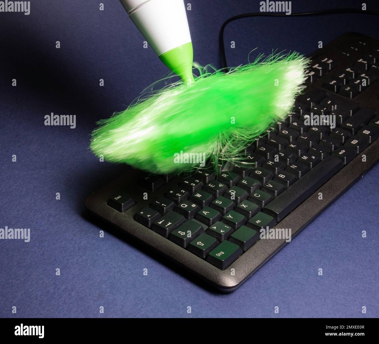 cleaning a computer keyboard from dust with an electric brush Stock