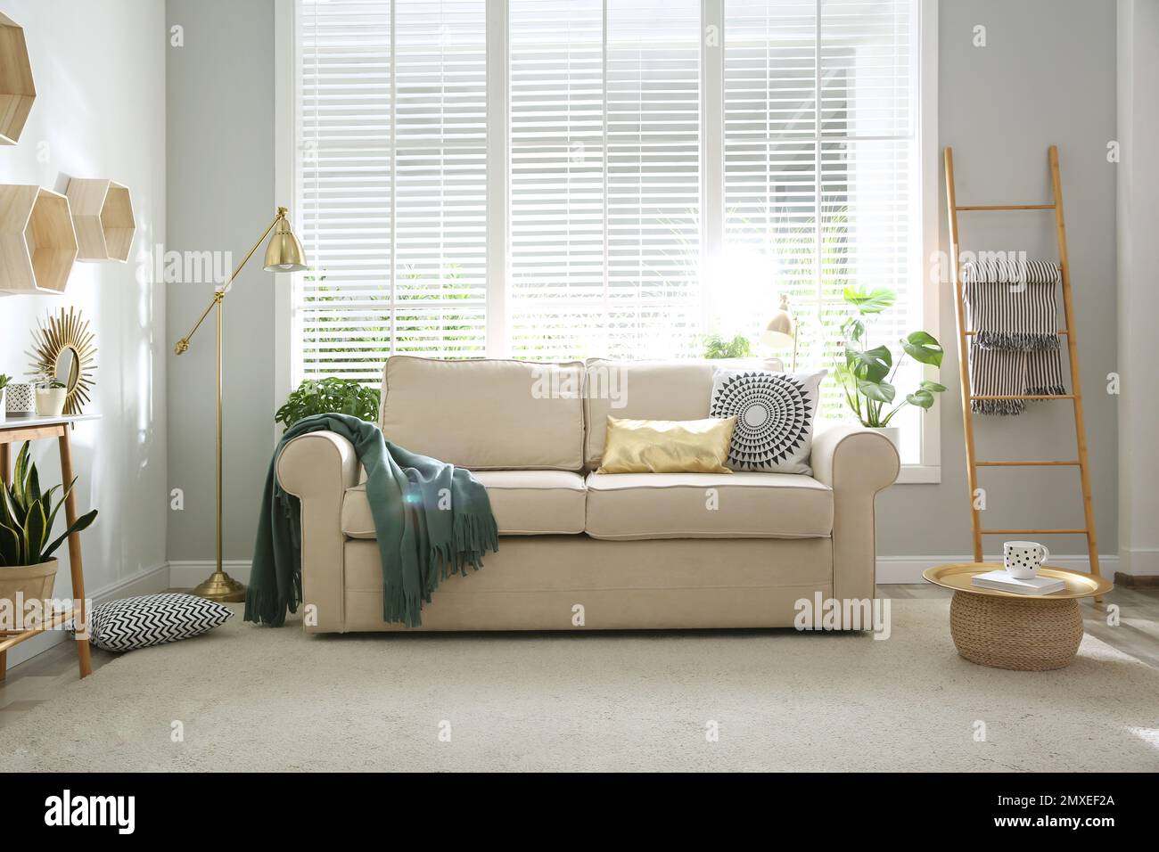 Stylish beige sofa in modern living room interior Stock Photo - Alamy