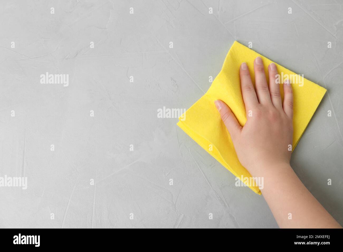 Woman wiping grey table with rag, top view. Space for text Stock Photo ...