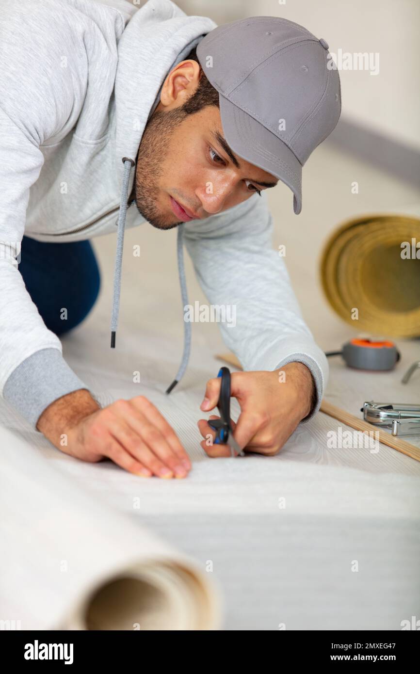 man cutting flooring with scissors Stock Photo Alamy