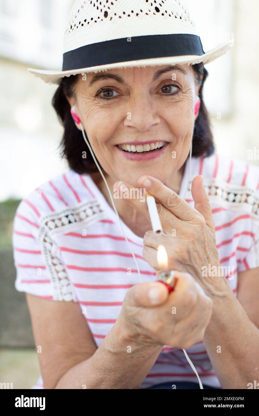 old woman smoking a cigarette in the park Stock Photo