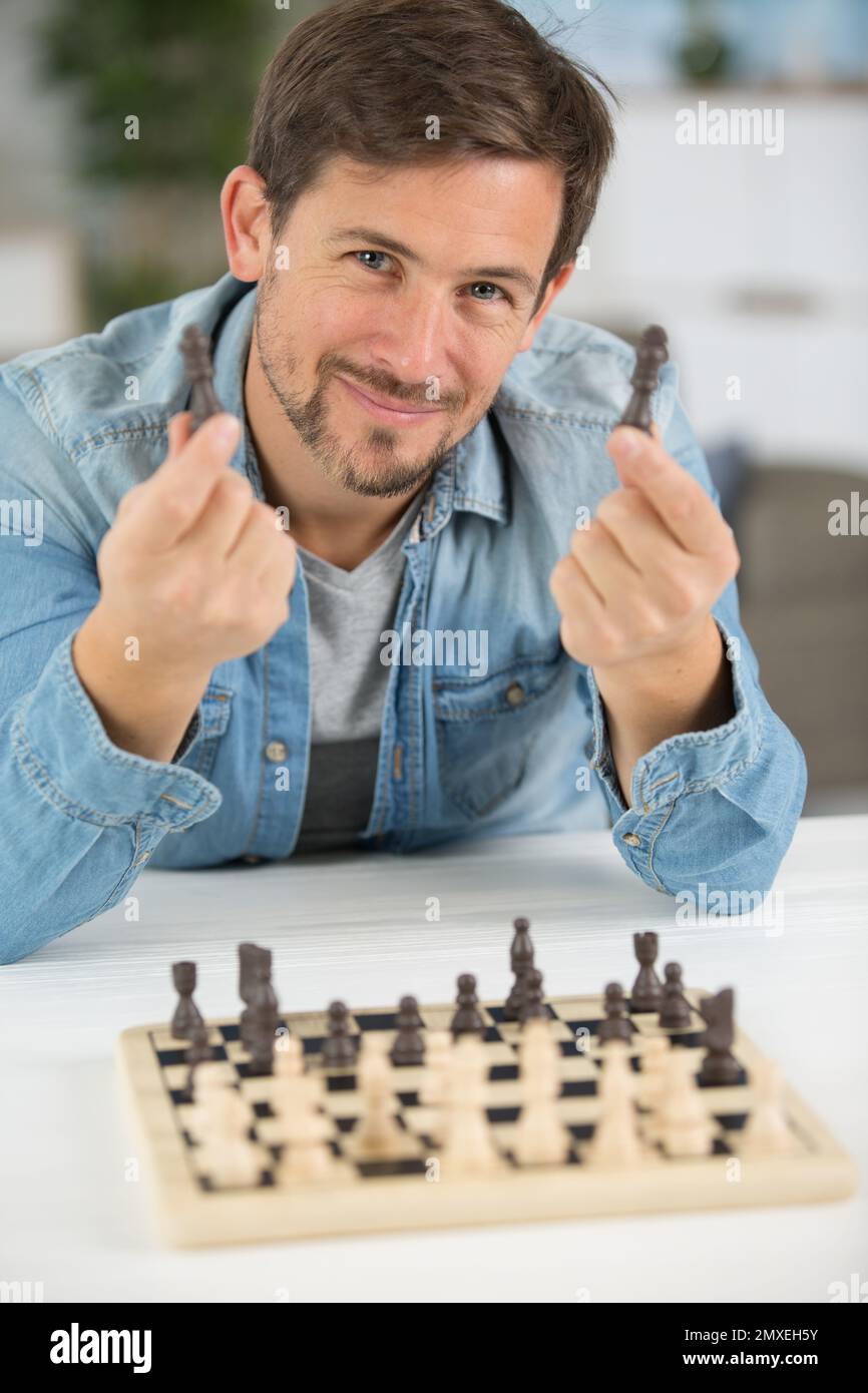 young man holding chess pieces Stock Photo - Alamy