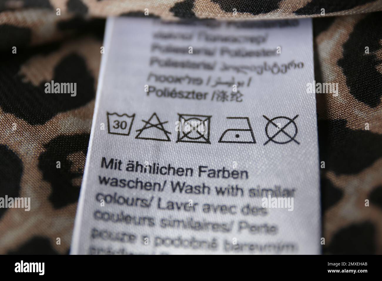 Clothing label with care symbols on shirt, closeup view Stock Photo