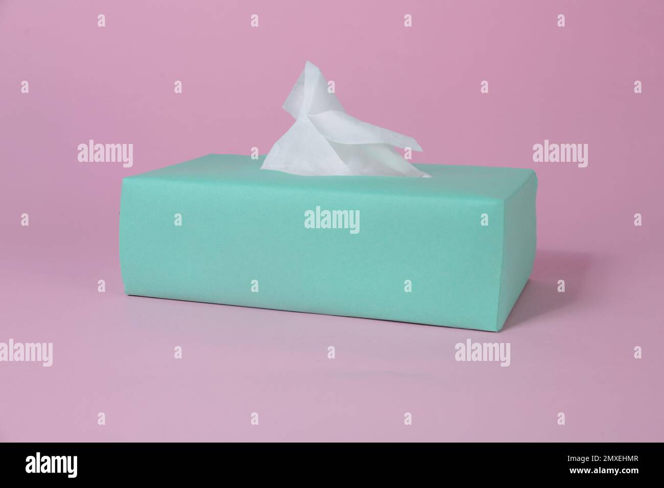 Box with paper tissues on pink background Stock Photo