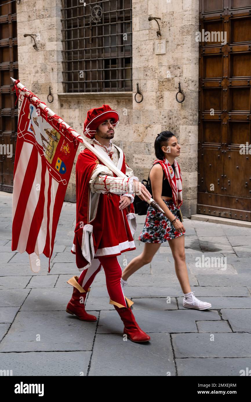 Siena, Tuscany, Italy - August 15 2022: Giraffa or Giraffe Contrada Flag Bearer in Renaissance Historical Costume and Contrada Member or Supporter at Stock Photo