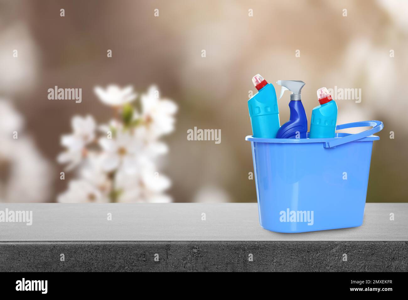 Bucket with cleaning supplies on stone surface outdoors. Space for text ...