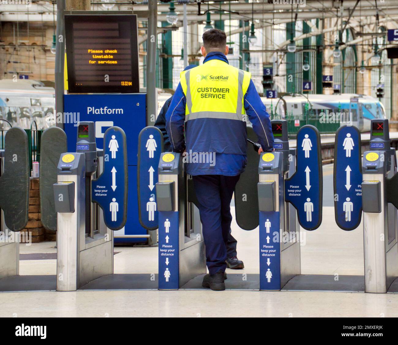 customer service operator ticket collector  on the barrier at central railway station Glasgow, Scotland, UK Stock Photo