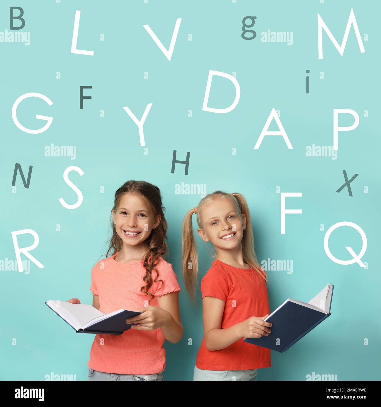 Little girls reading books on turquoise background Stock Photo - Alamy