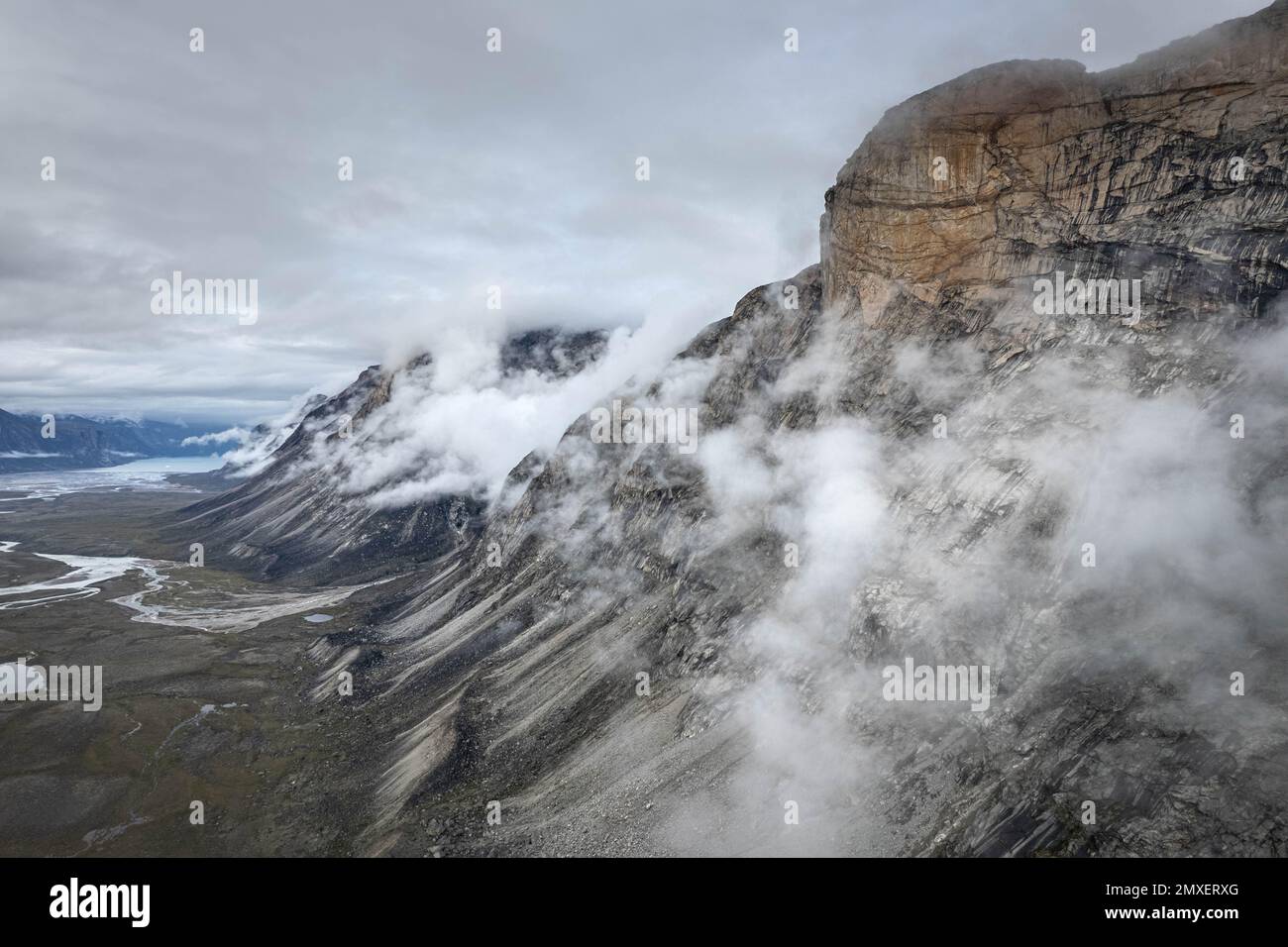 Dark atmospheric surreal landscape with dark rocky mountain top in low ...