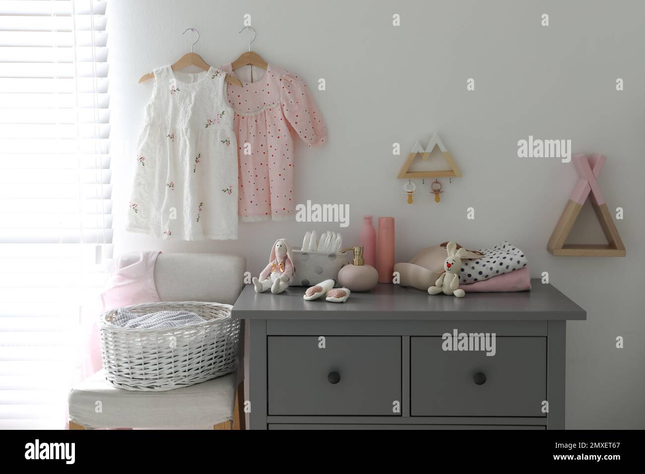Stylish chest of drawers and accessories in child room Stock Photo
