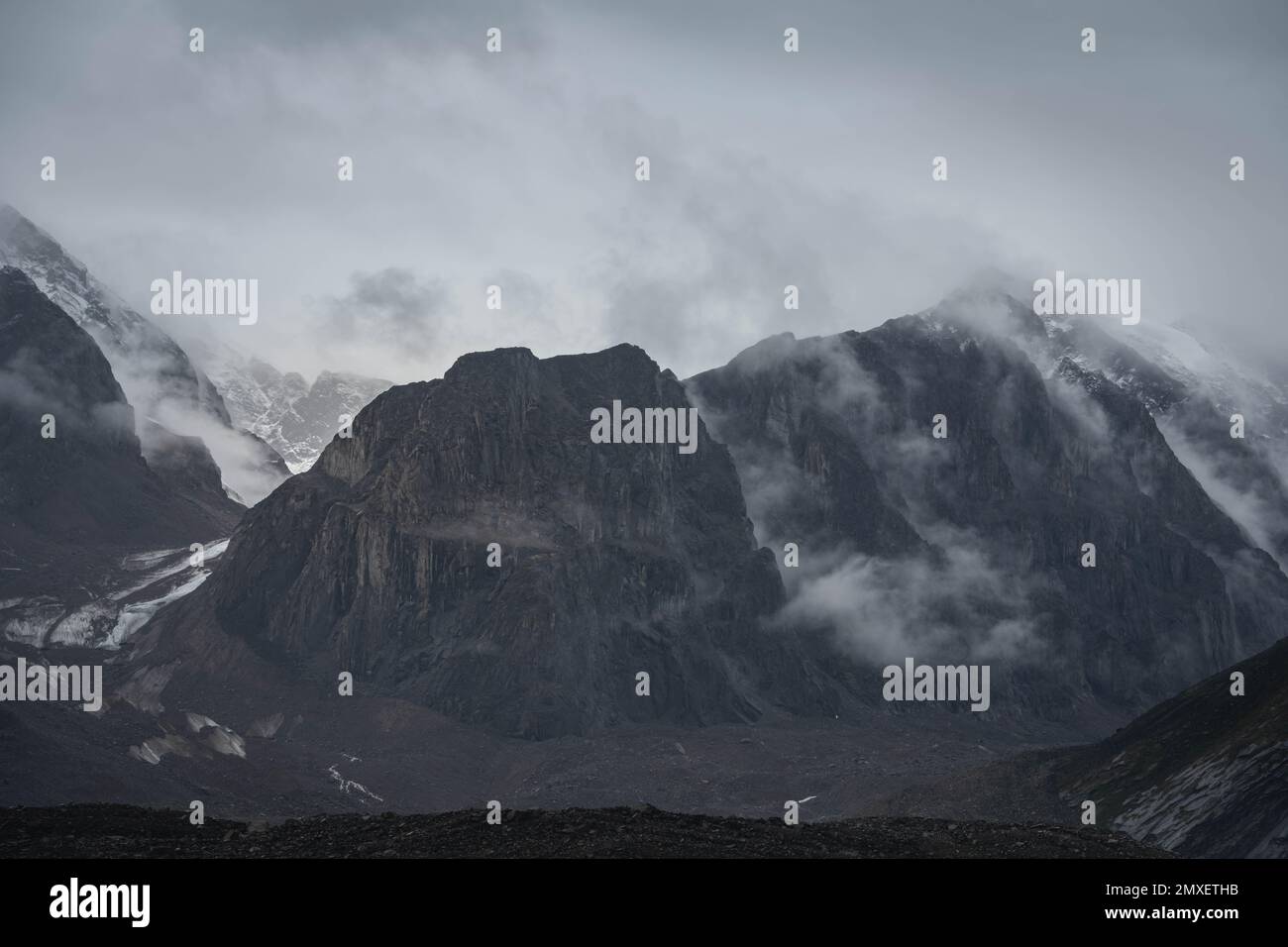 Dark atmospheric surreal landscape with dark rocky mountain top in low ...