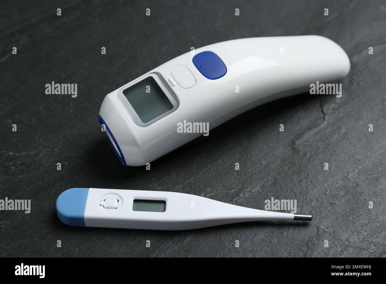 https://c8.alamy.com/comp/2MXEWHJ/non-contact-infrared-and-digital-thermometers-on-black-slate-background-2MXEWHJ.jpg