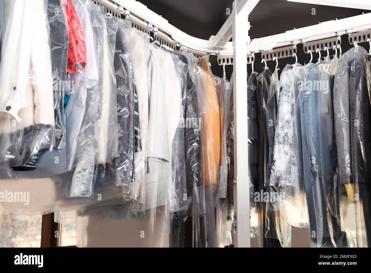 Hangers With Clothes On Garment Conveyor At Dry-cleaner's Stock Photo,  Picture and Royalty Free Image. Image 198000170.