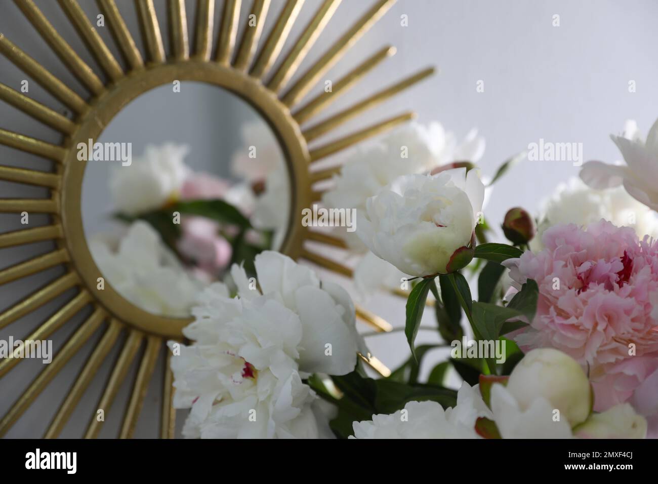 Bouquet of beautiful peony flowers near mirror, closeup Stock Photo