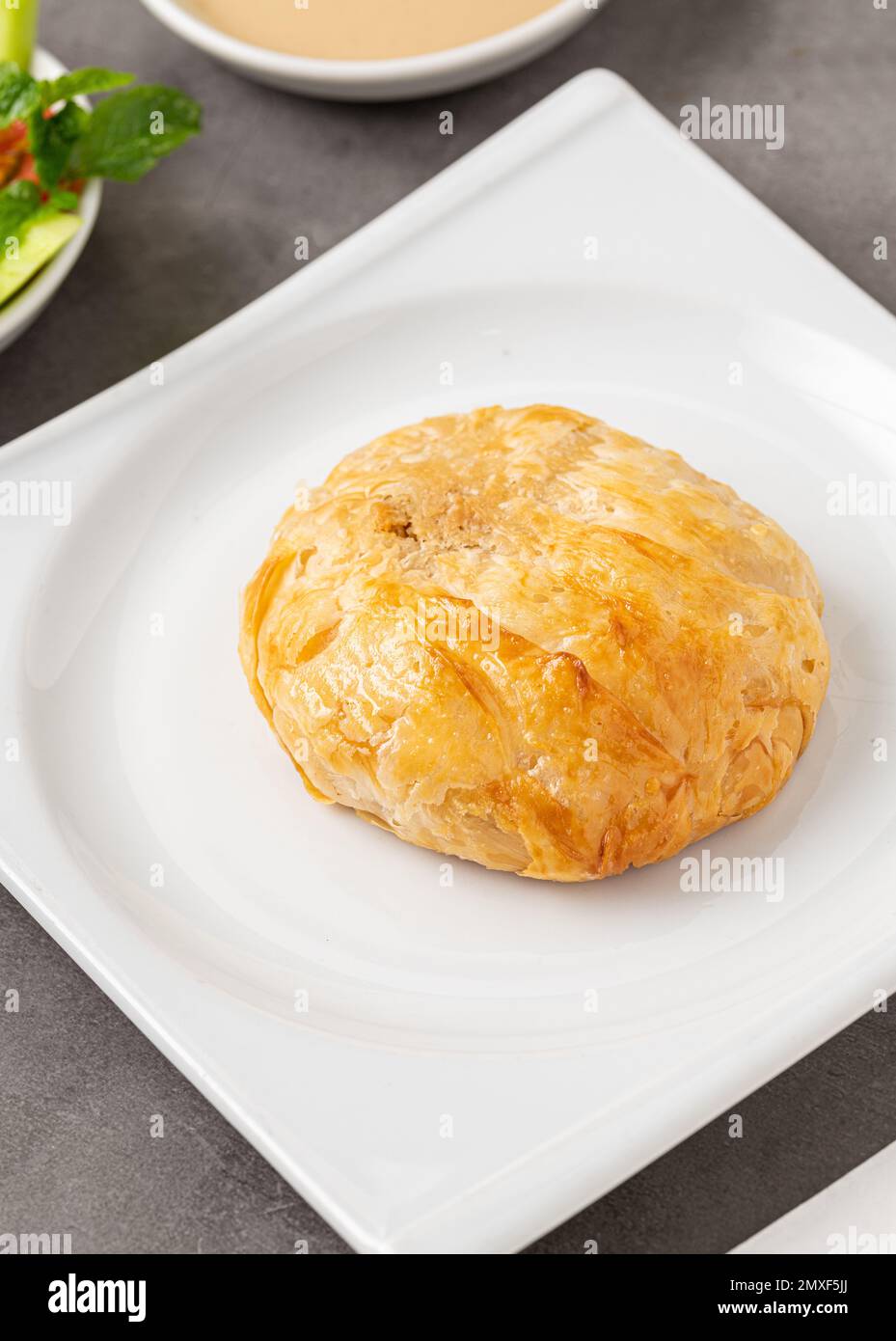 Izmir boyoz on a white porcelain plate on a stone table Stock Photo