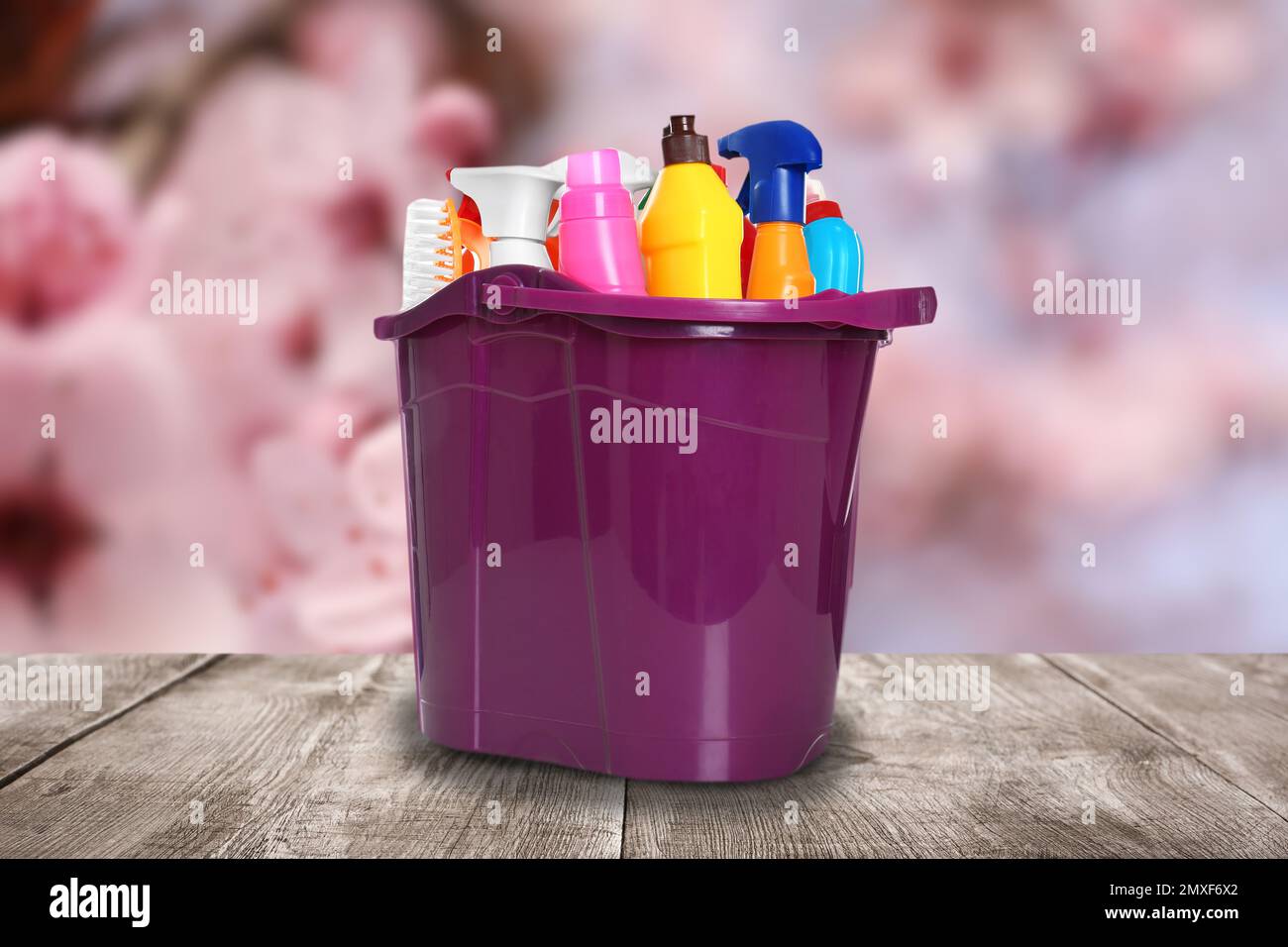 Bucket with cleaning supplies on wooden surface outdoors Stock Photo ...