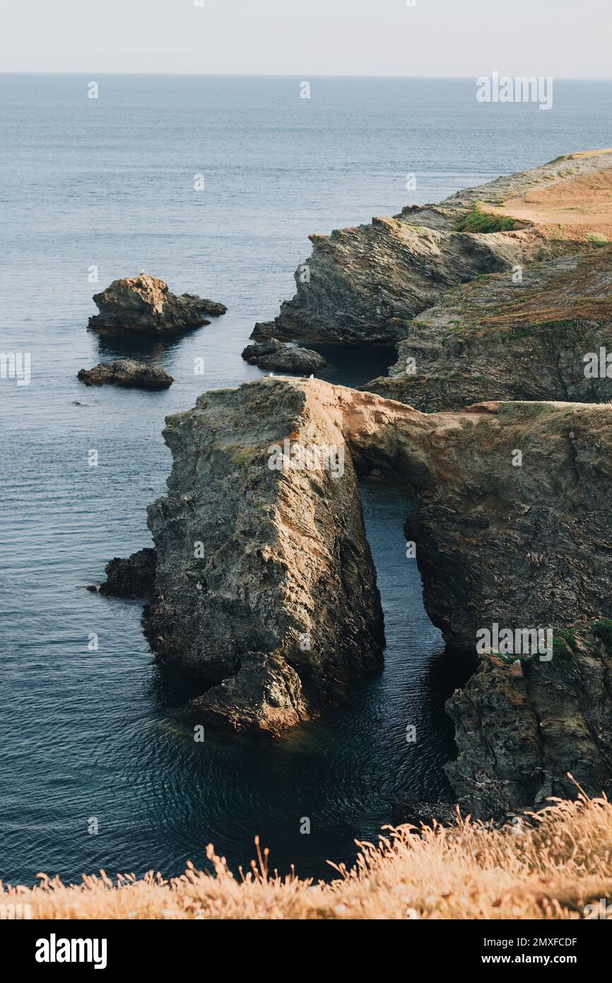 A vertical aerial view of huge rock pieces in the ocean in daylight ...