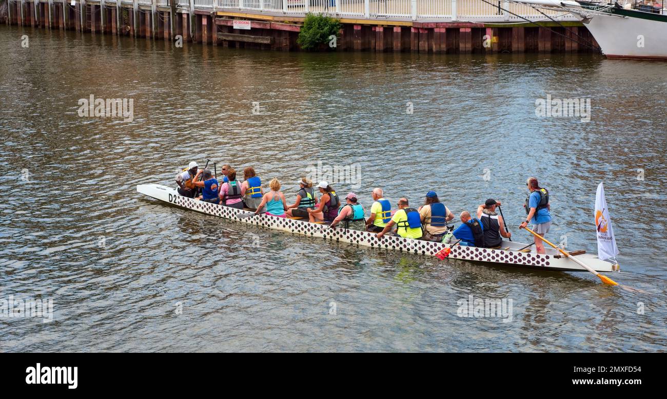 A dragon boat, a type of large kayak for a team of paddlers, rows by on