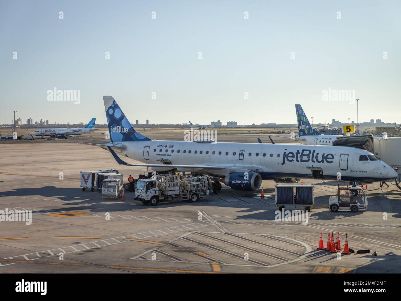 The JetBlue company airplane on the runway with ground support equipment Stock Photo Alamy