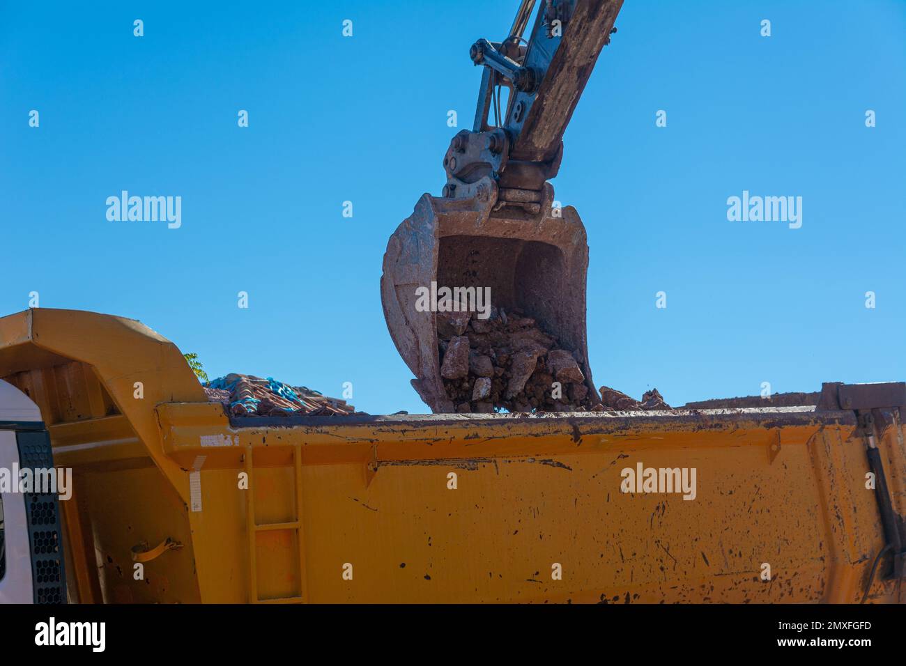 Heavy machinery works at the construction site. Clearing rocky soil for ...