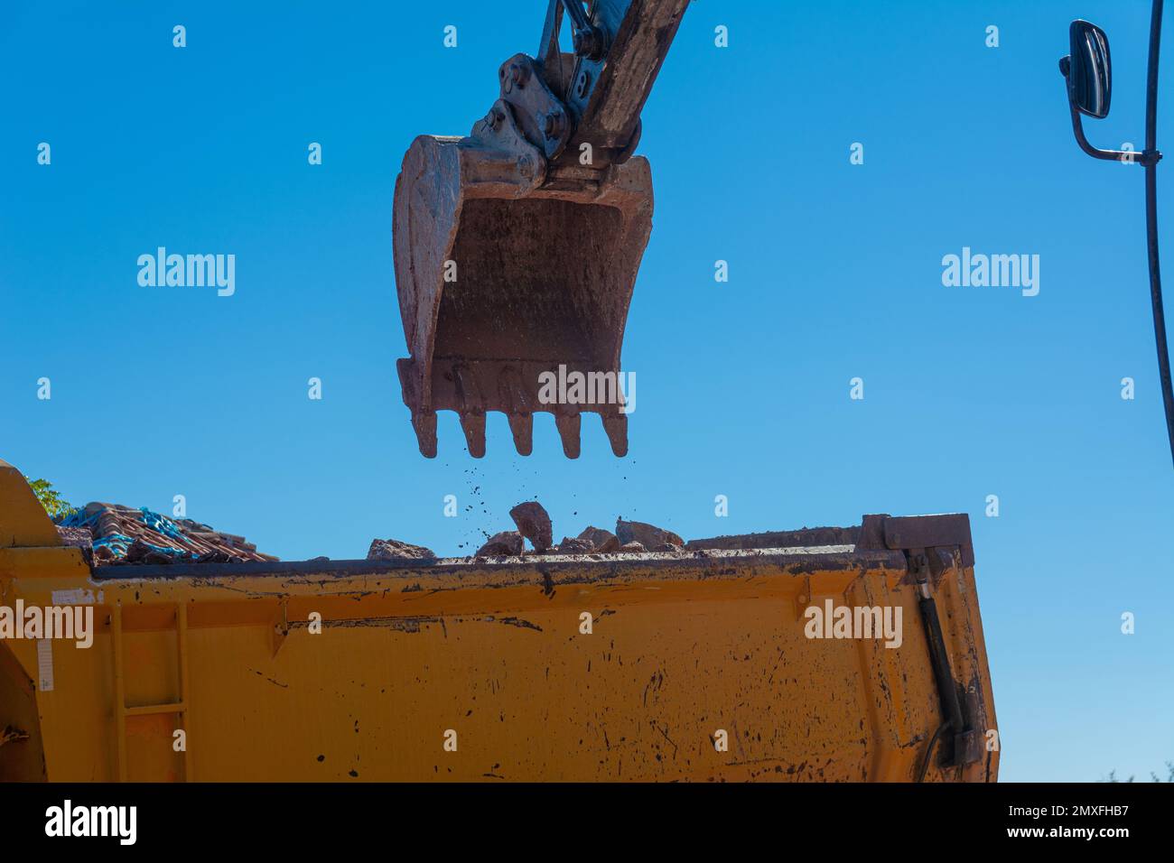 Heavy machinery works at the construction site. Clearing rocky soil for ...