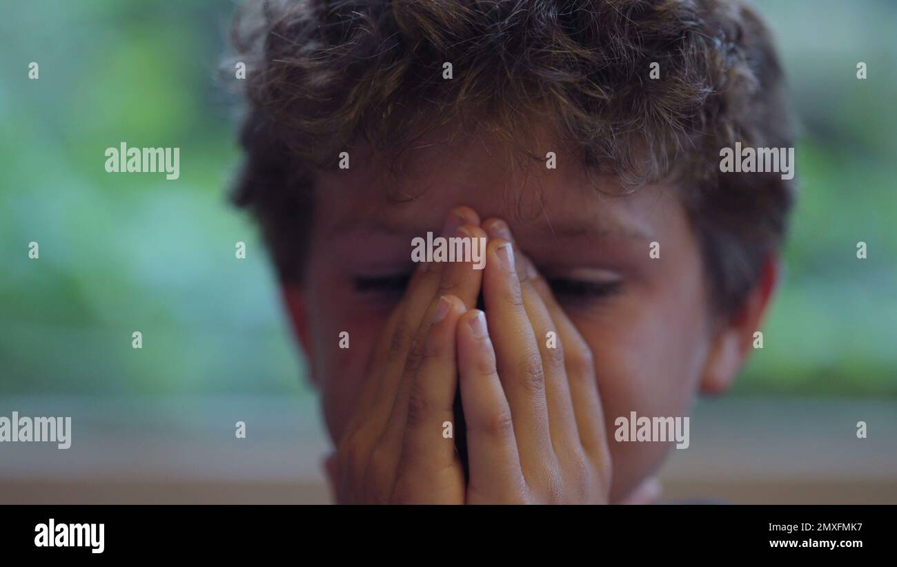Child rubbing face kid with worried emotion Stock Photo Alamy