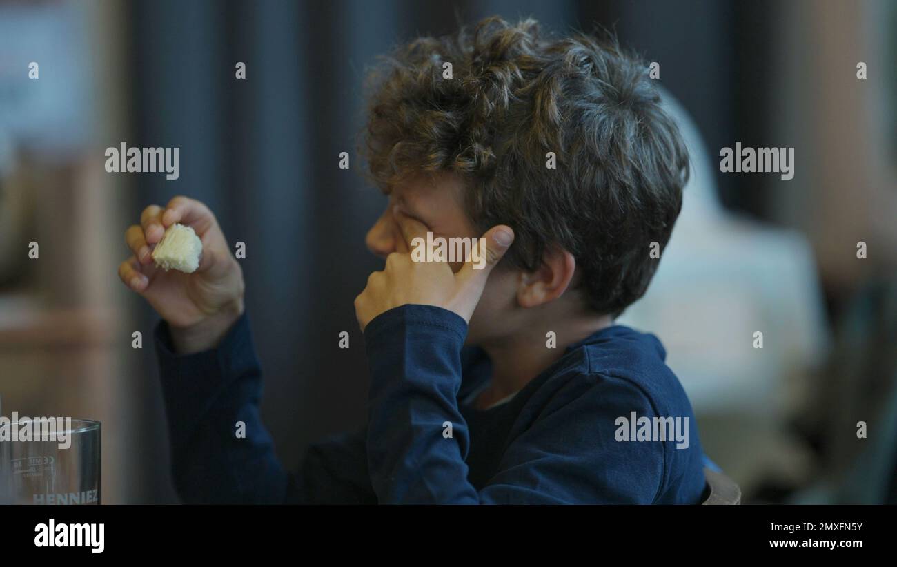 Child scratching eye with finger candid boy touching face Stock Photo