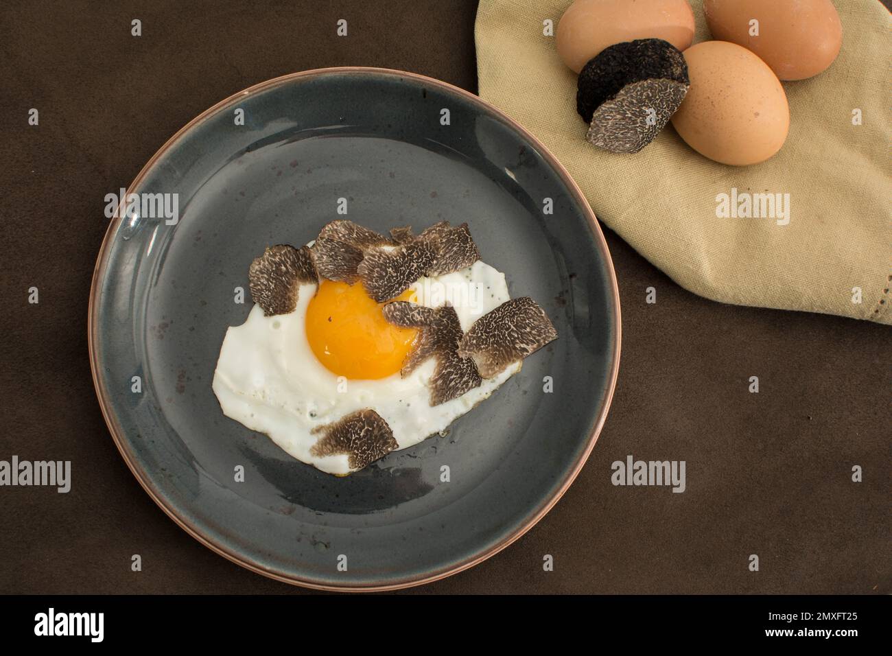 Fried Truffled eggs with a tuber melanosporum winter truffle Stock