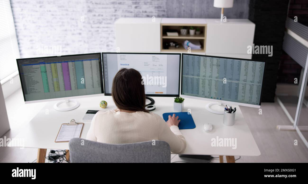 Using Corporate Invoice Spreadsheet On Computer Monitors Stock Photo