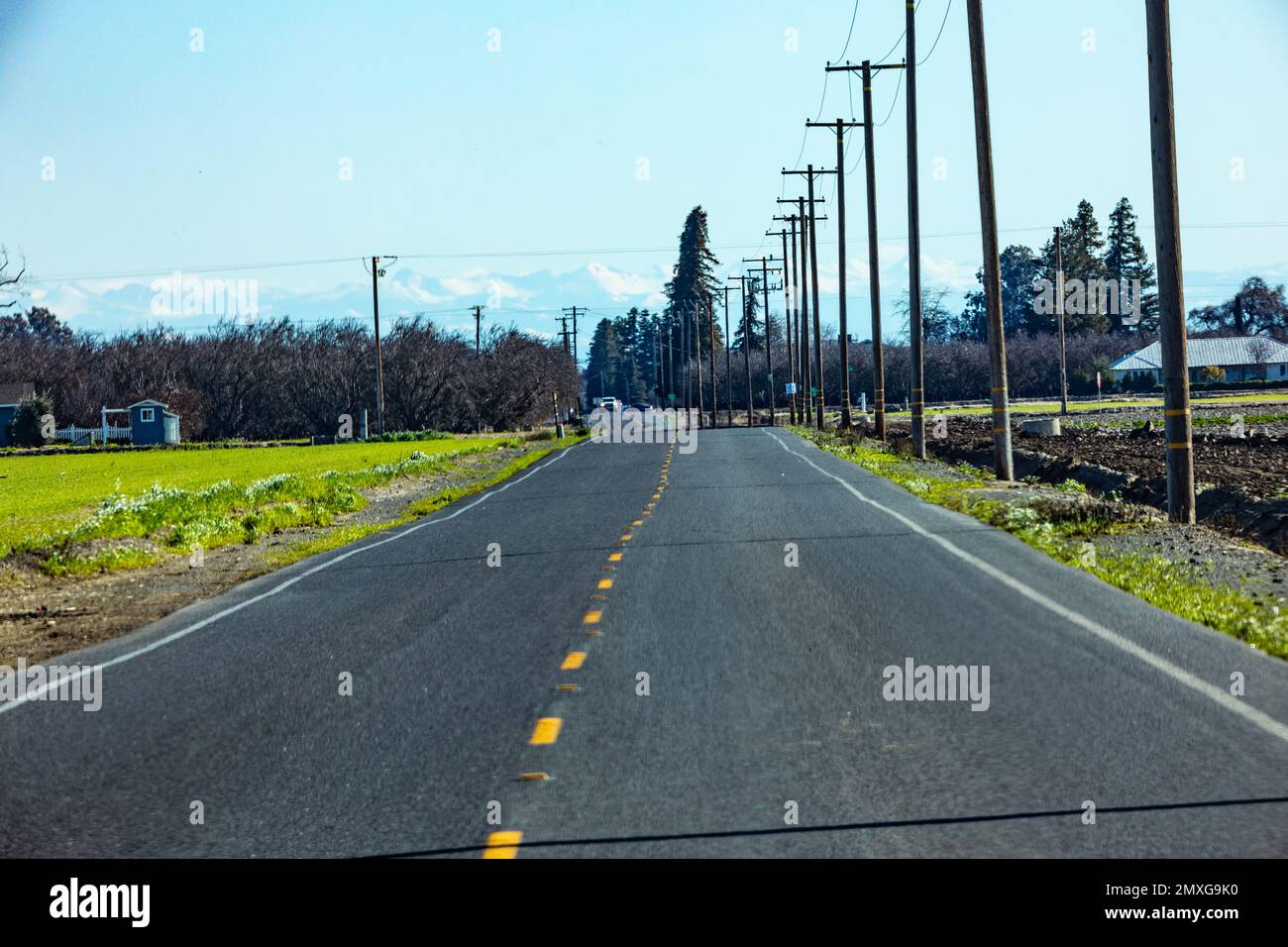 Telephoto lens compression is demonstrated in this photo of a road and telephone poles Stock Photo