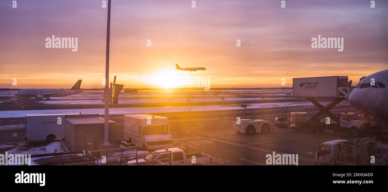 An airplane landing at JFK Airport in New York during sunrise, United