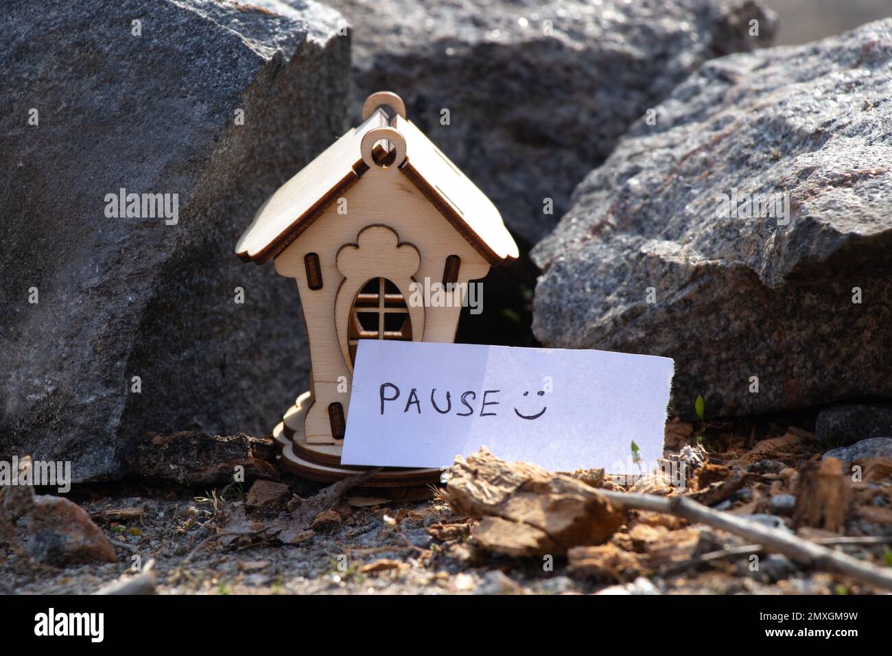 a wooden house stands on the ground in the sun and next to it is an