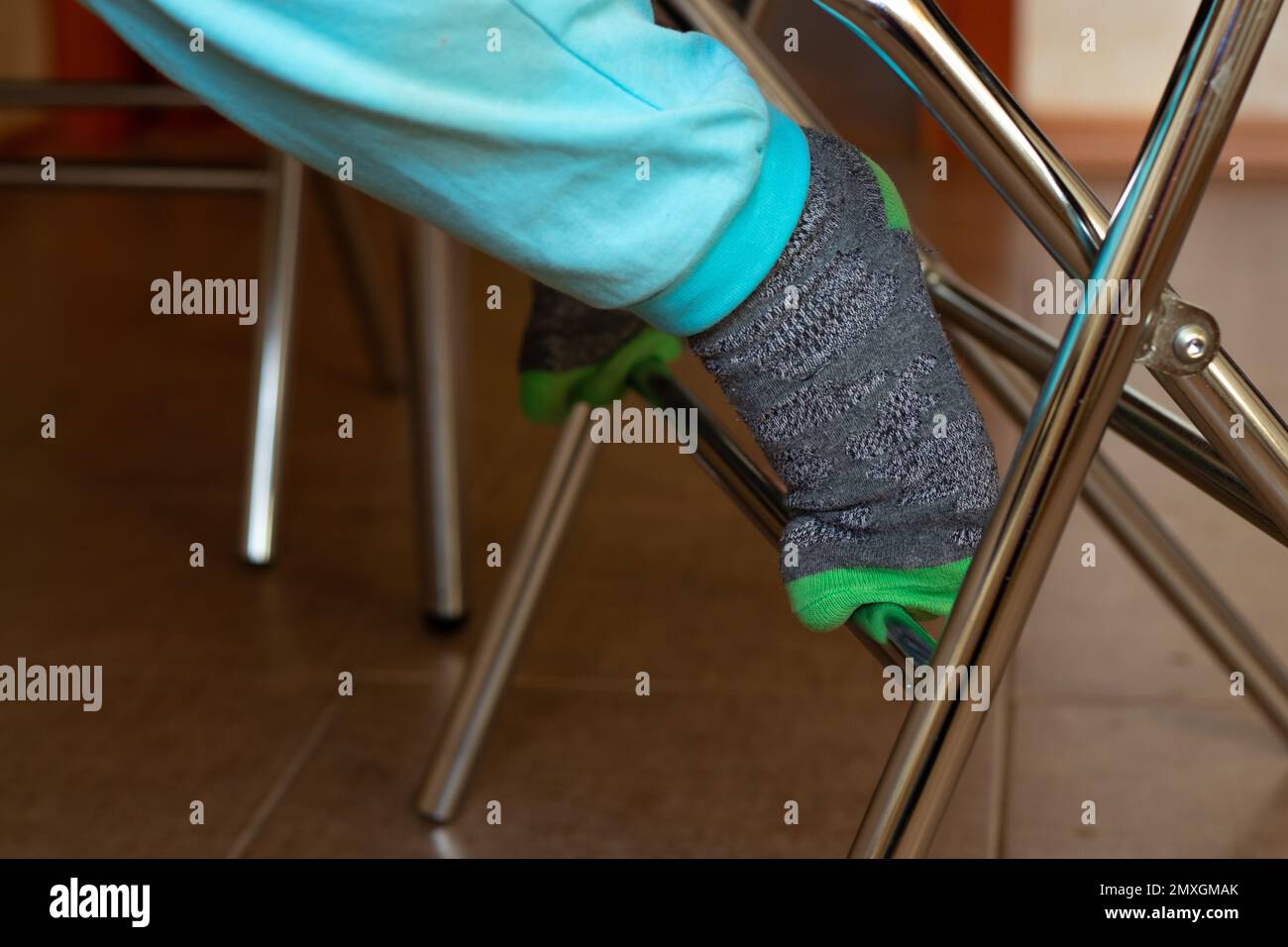 children's foot on a chair in the kitchen Stock Photo