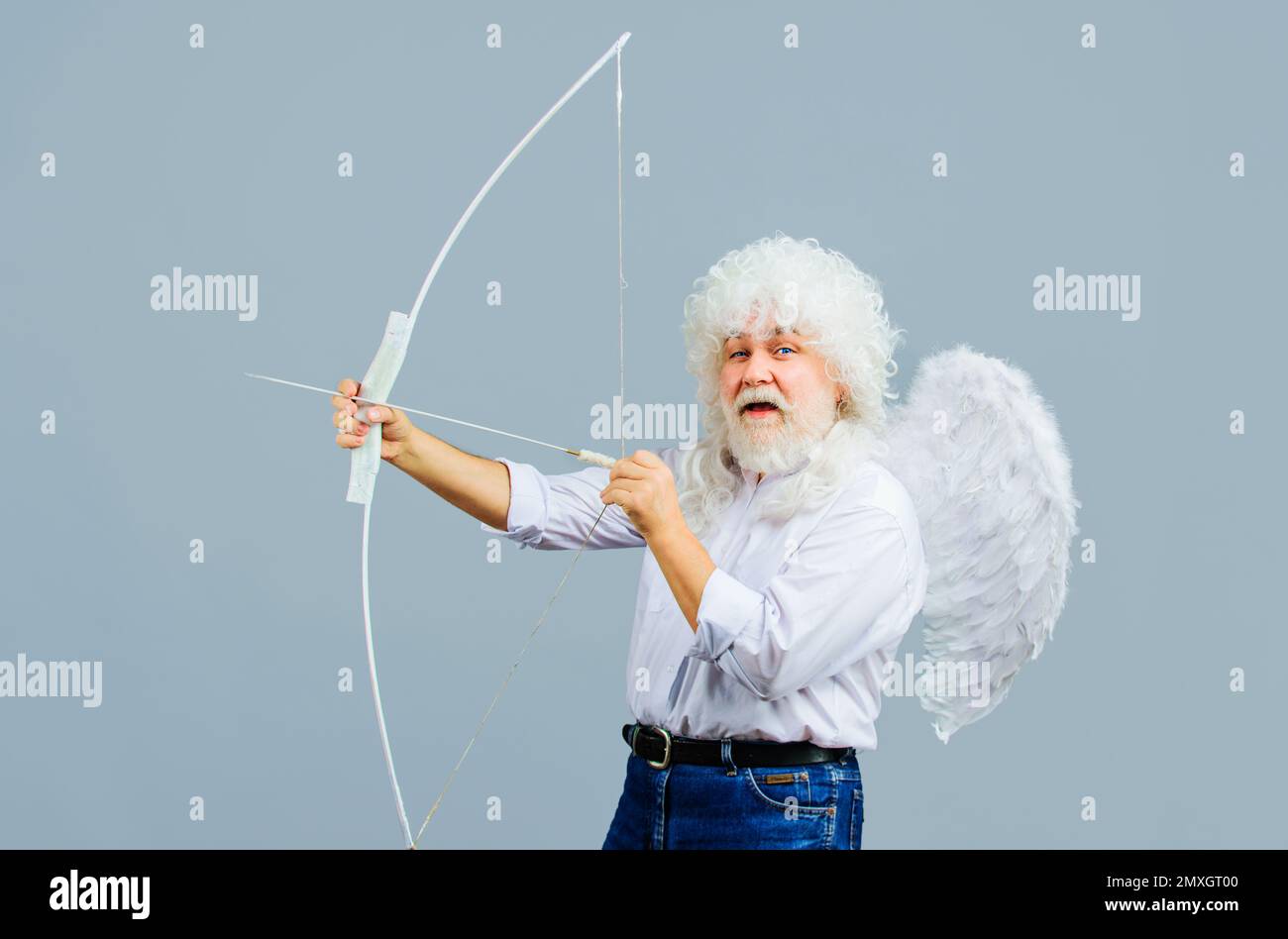 Valentines Day. Male angel aiming with bow and arrow. Cupid in angelic wings. God of love. Stock Photo