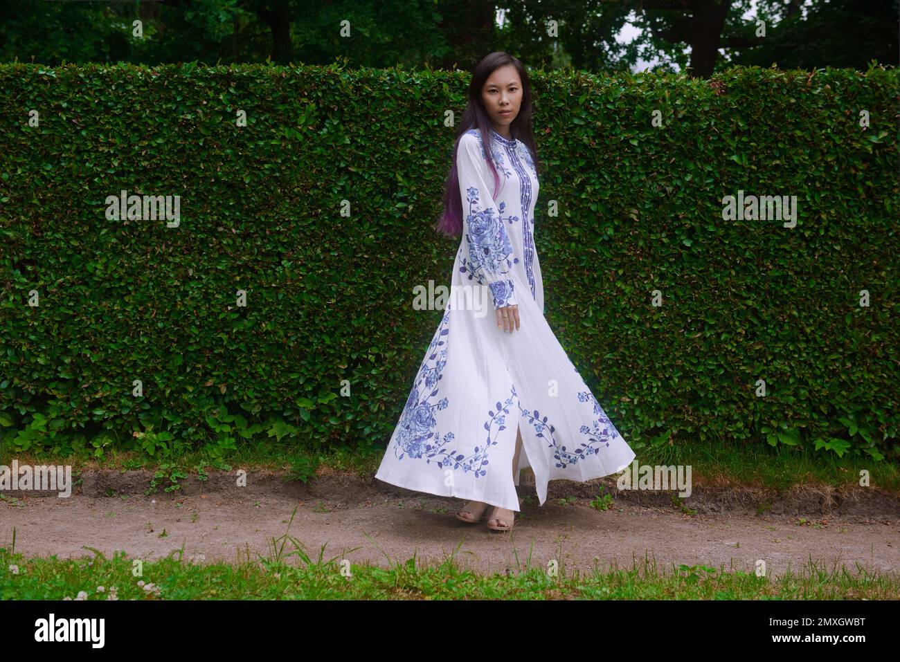 Vietnamese young woman in a long light dress at the park Stock Photo