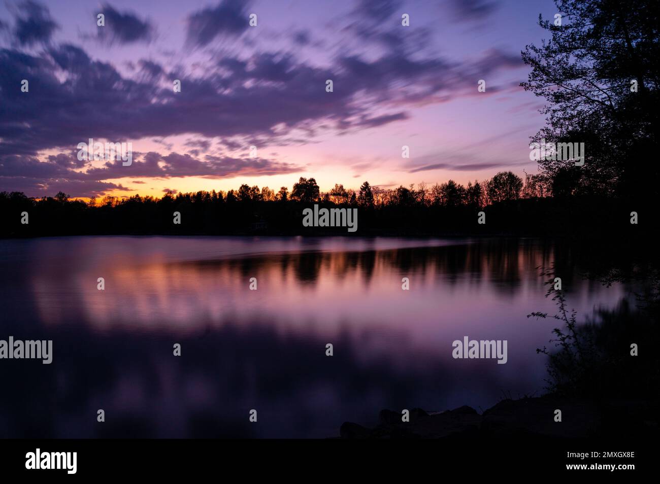 A scenic view of a tranquil lake surrounded by trees during a ...