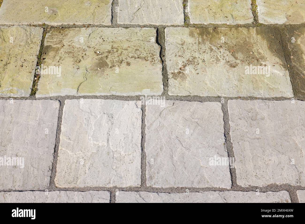 Cleaning garden patio. Sandstone paving before and after jet washing or pressure washing, UK