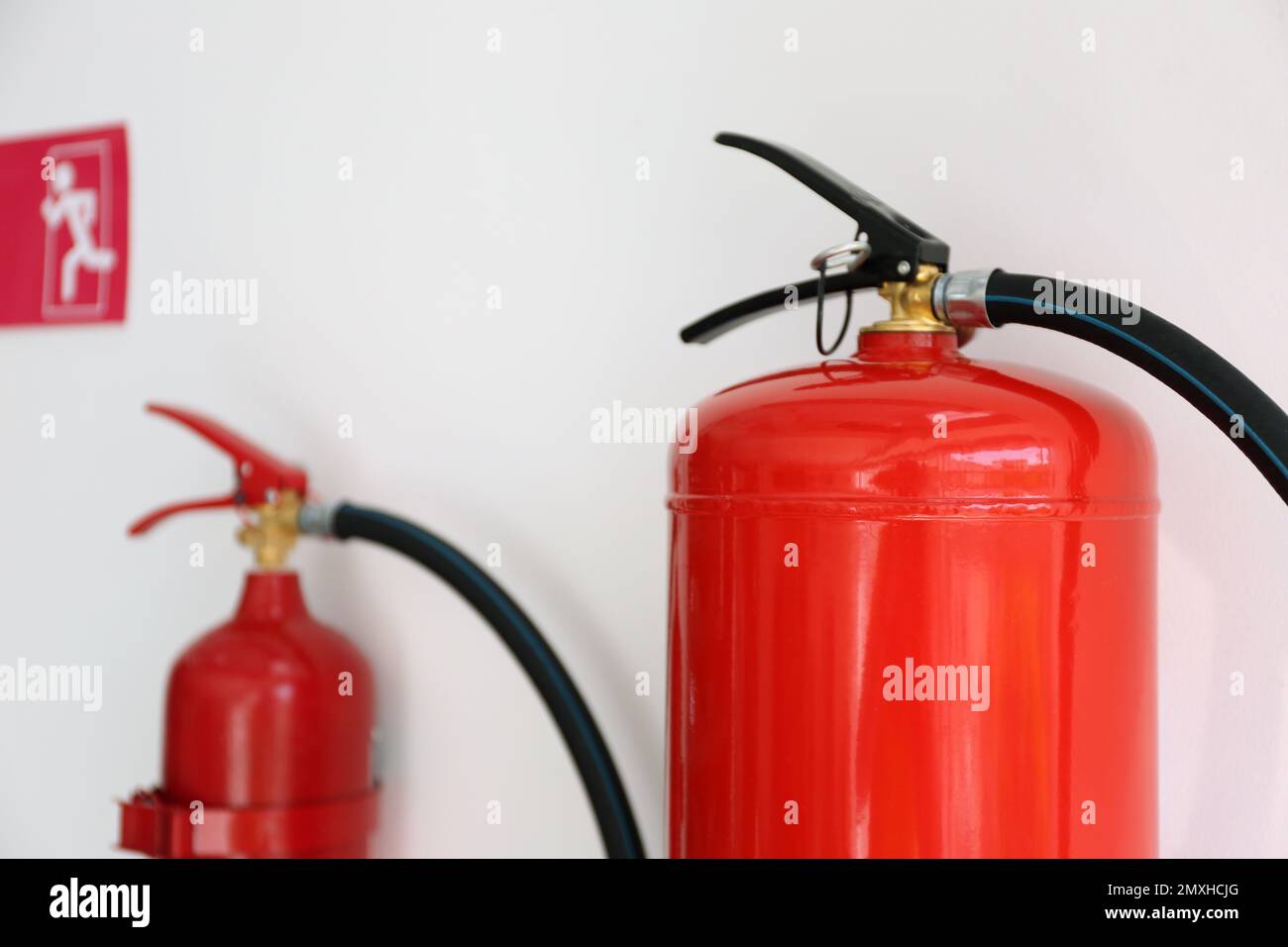 Fire extinguishers hanging on white wall, closeup Stock Photo Alamy