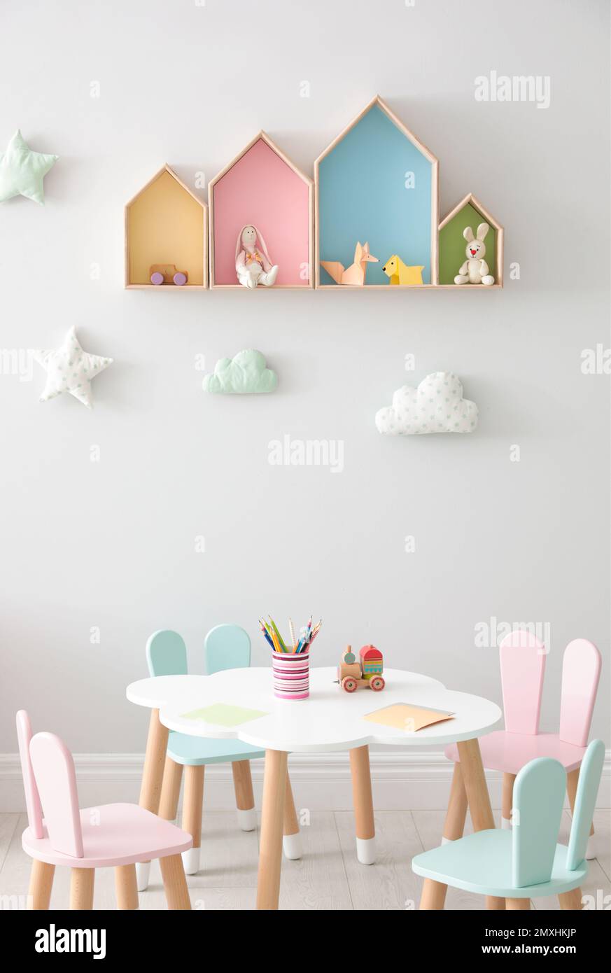 House shaped shelves and little table with chairs in children's room. Interior design Stock Photo