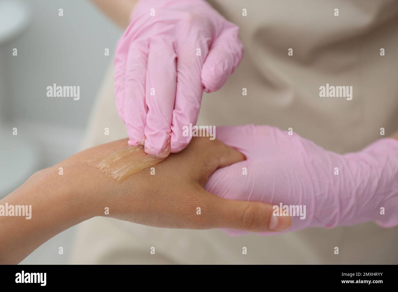 Woman getting wax epilation of hand in salon, closeup Stock Photo