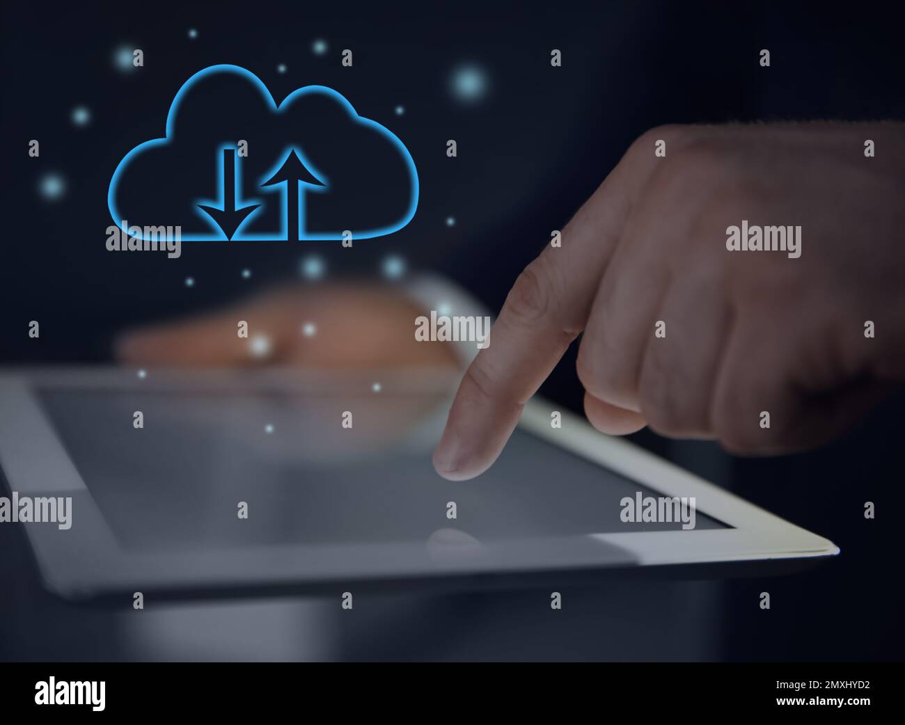 Cloud computing and storage concept. Man using tablet on dark background, closeup Stock Photo