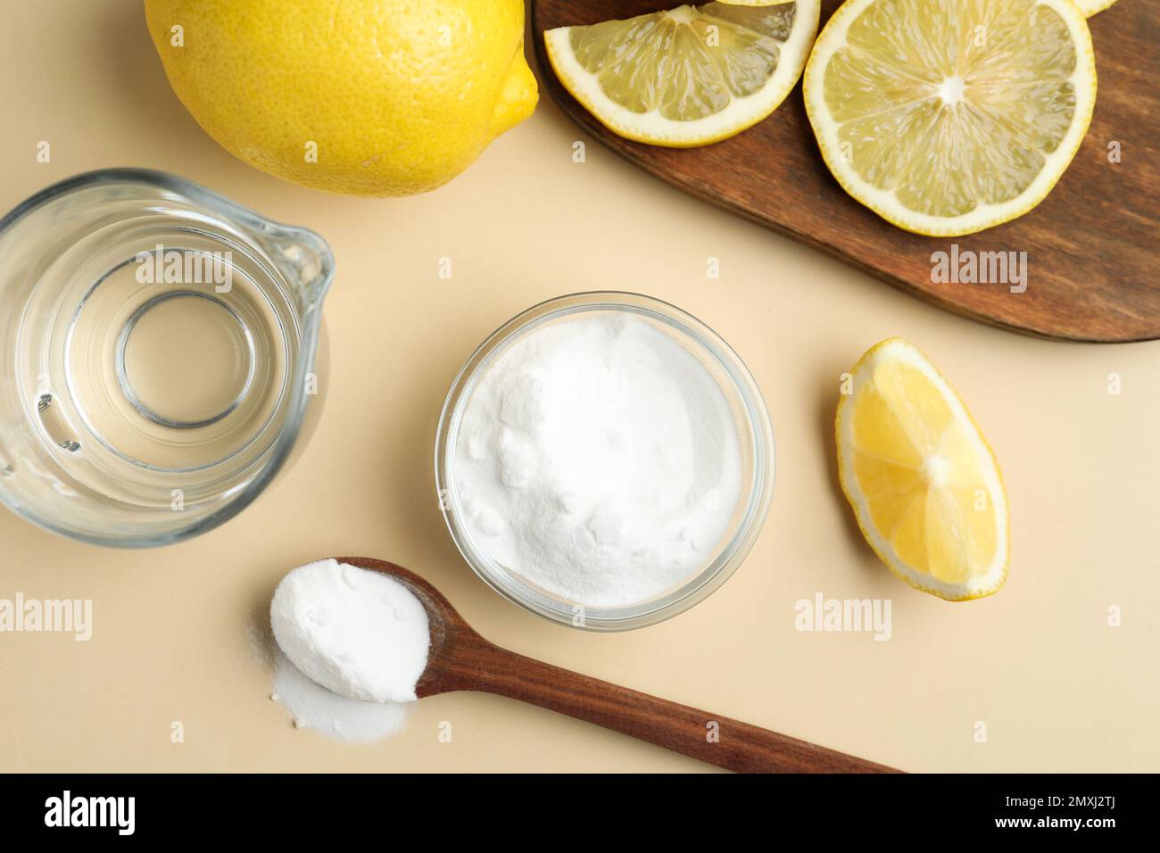 Baking soda, lemons and vinegar on beige background, flat lay Stock