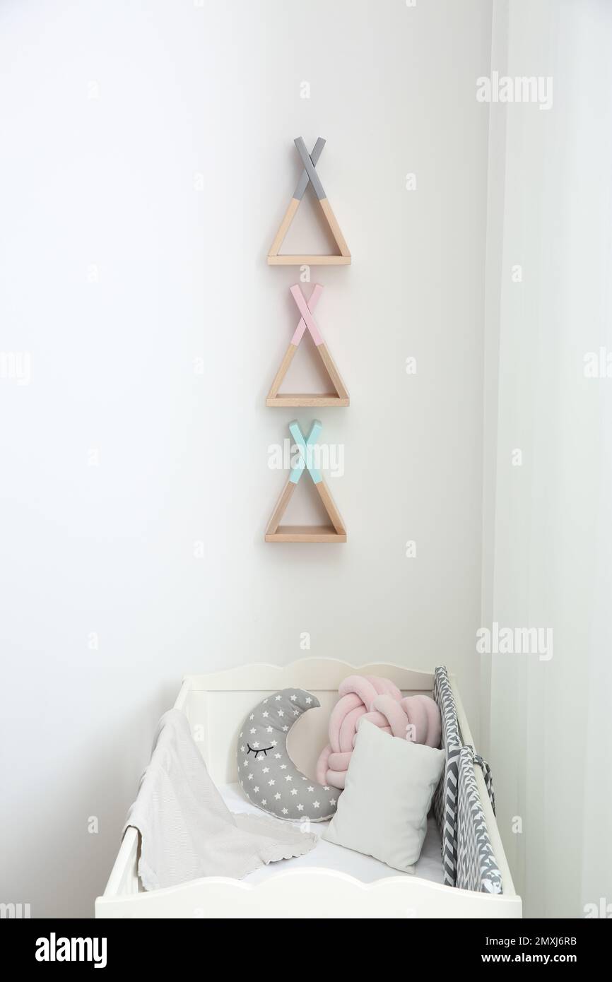 Wigwam shaped shelves over crib in baby room. Interior design Stock