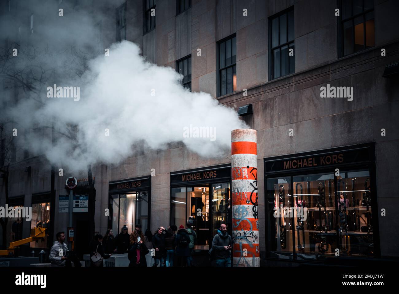 A closeup of a sewer with steam coming out in the streets of Manhattan, New York City Stock Photo