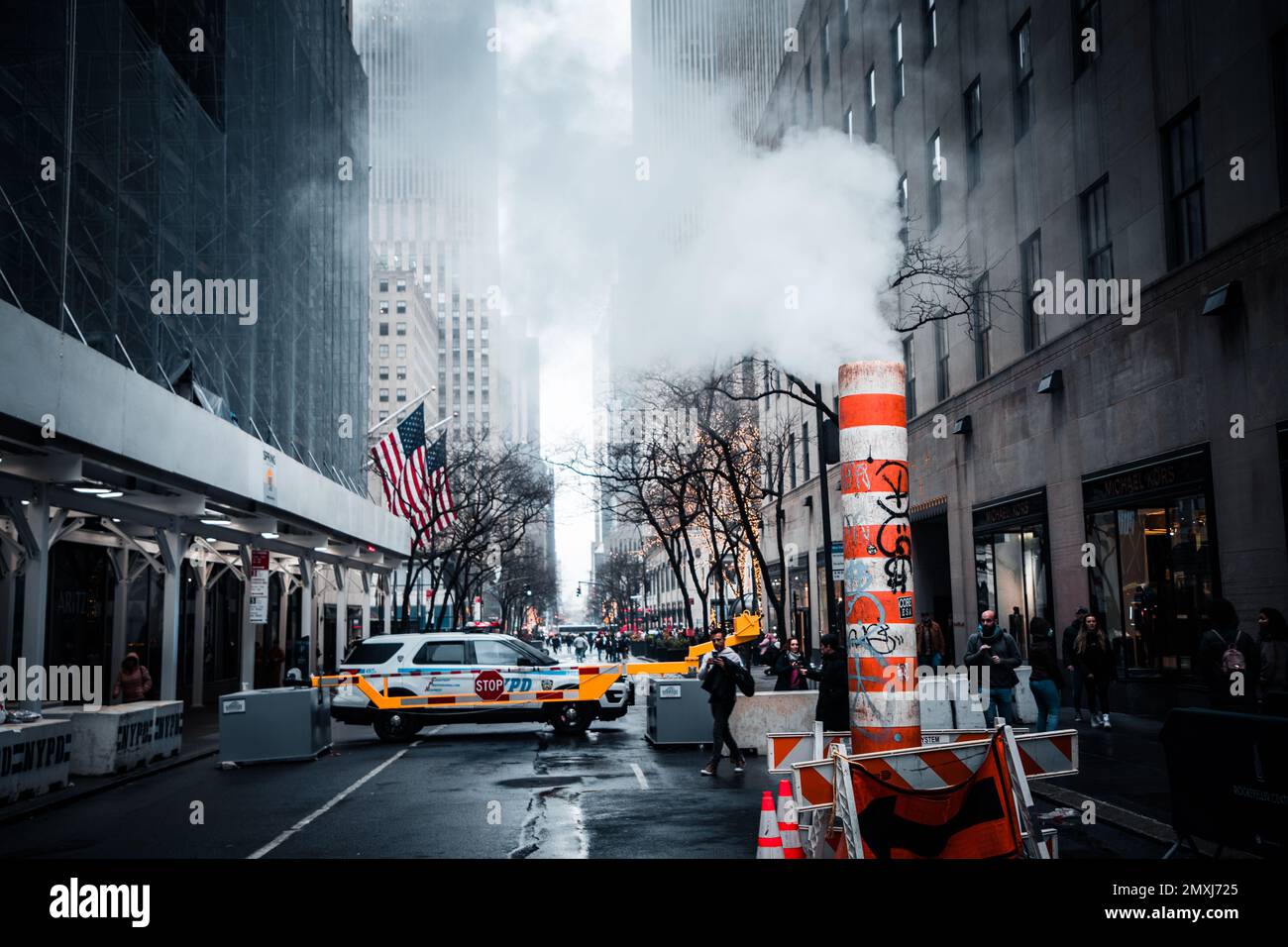 A closeup of a sewer with steam coming out in the streets of Manhattan, New York City Stock Photo