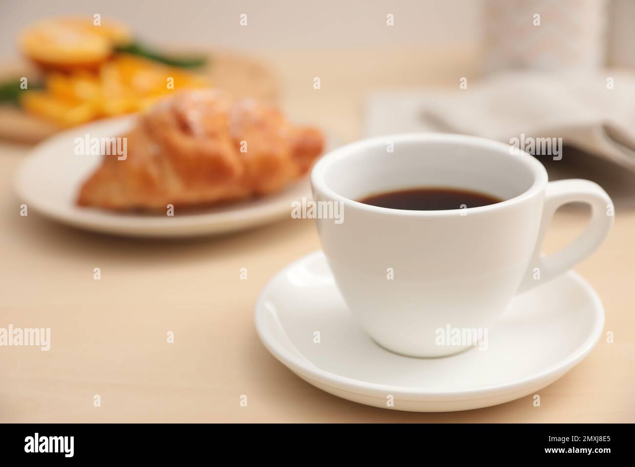 Cup of hot aromatic coffee and tasty croissant on table Stock Photo - Alamy