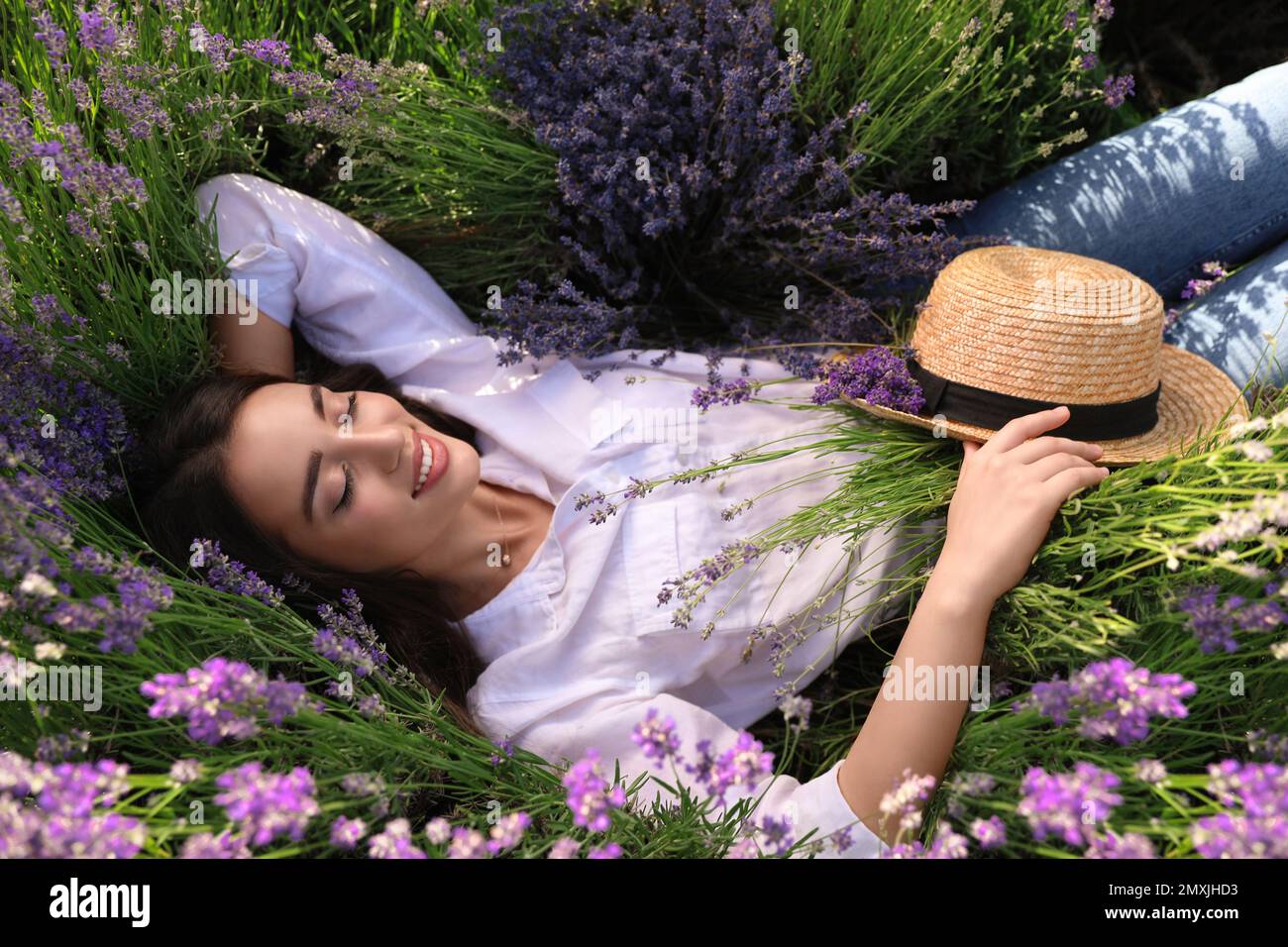 Young woman lying in lavender field on summer day Stock Photo Alamy