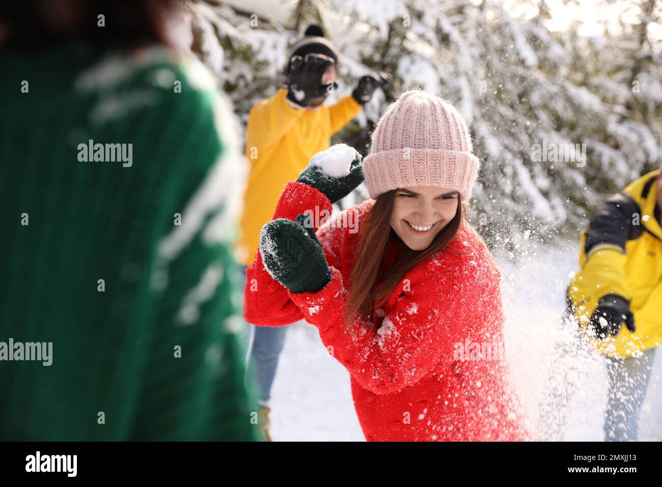 Happy friends playing snowballs outdoors. Winter vacation Stock Photo ...