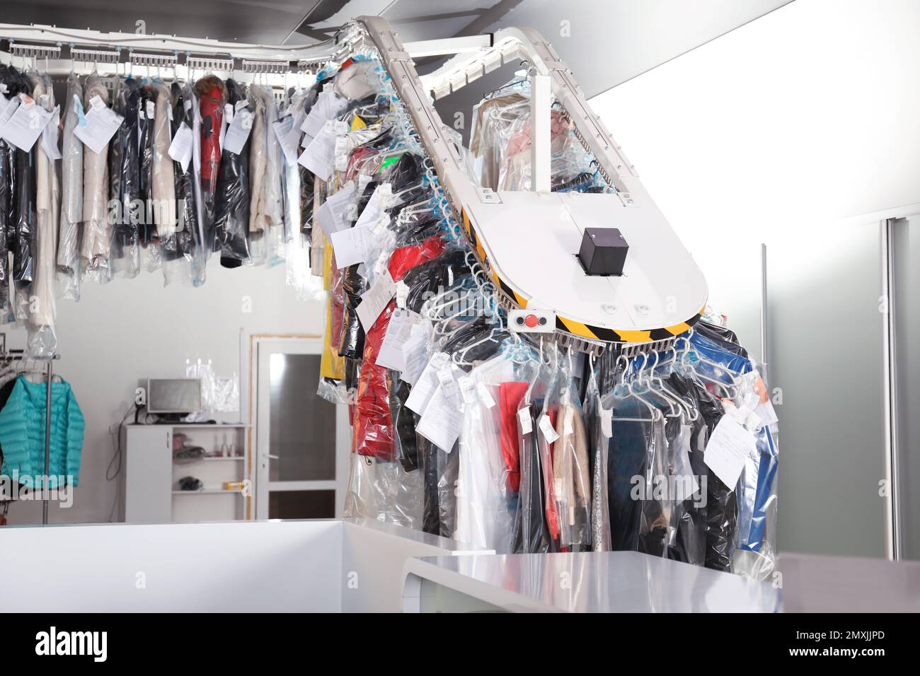 Modern drycleaner's interior with counter and garment conveyor Stock